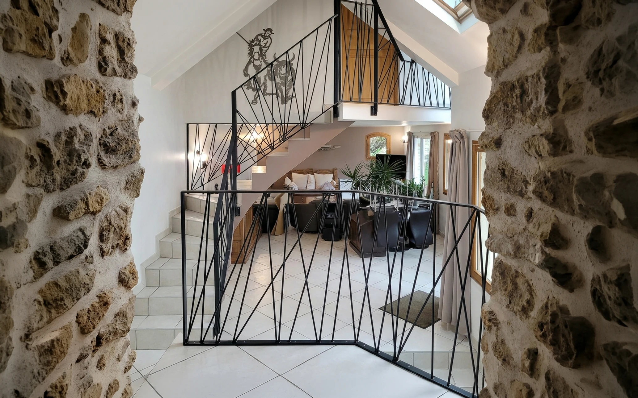 Escalier monumental en colimaçon avec rampe en fer forgé ornementée, balustres sculptés et marches en pierre naturelle